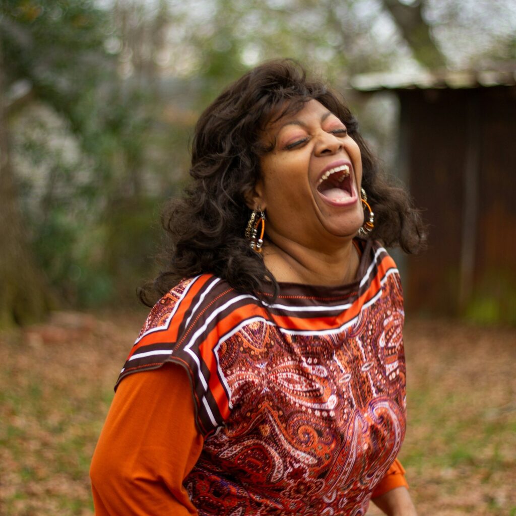 Woman laughing freely outdoors in autumn light