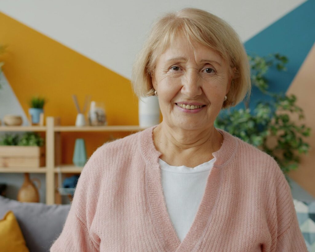 Mature woman smiling gently at home in a colorful living room